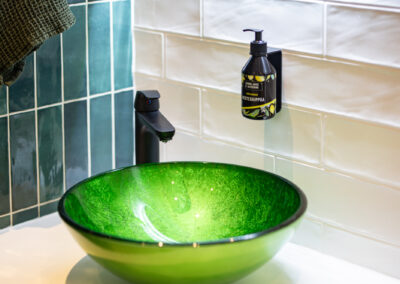 Omakotitalon sisustussuunnittelu, wc, vihreä lasiallas, tammi vesikalusteet